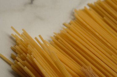 Glütensiz spagetti yakın çekim. Buğday unundan yapılmış glütensiz spagetti. Bu spagetti alerjik reaksiyonlara neden olmaz. Mermer masada servis edilir..
