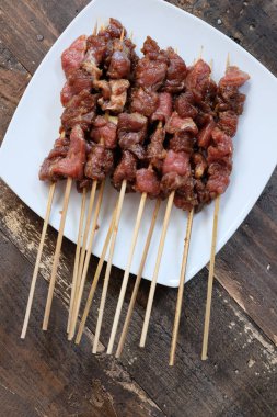 Beyaz seramik tabakta Sate Sapi bifteği satay. Satay kömürde kızarmadı. Geleneksel Endonezya yemekleri, soya soslu, sarımsaklı, biberli, sonra da şiş..