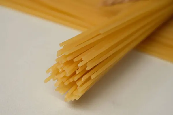 グルテンフリースパゲティのクローズアップ 全小麦粉から作られたグルテンフリースパゲティ このスパゲティはアレルギー反応を引き起こさない 大理石のテーブルの上で — ストック写真