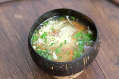 Soto Ayam Bathok, hindistan cevizi kabuğuyla servis edilen tavuk çorbası ile servis edilen berrak tavuk çorbası. Hindistan cevizi kabuğu yiyecek kabı olarak kullanılabilir. Endonezya yemekleri.