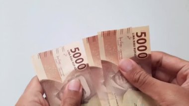 Eller Endonezya rupia paralarını sayıyor. Beş bin rupia değerinde..