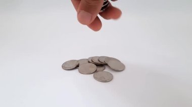 Bozuk paraların içine bozuk para atan el kameraları. Beyaz arka planda bin rupia sikke.