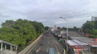 Lenteng Agung, Güney Jakarta 'da bir caddedeki trafik manzarası. Yolcuları almak ve bırakmak için bir otobüs durağı..
