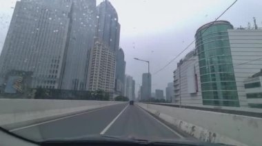 Güney Jakarta 'daki Casablanca üstgeçidinde hareket halindeki bir arabanın içinde trafik durumu görülüyor. Yağmurlu gün ve su damlaları.