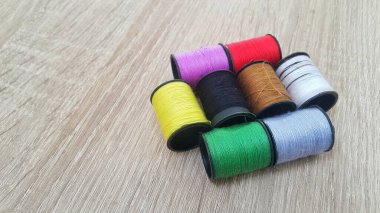 Ahşap masada renkli dikiş ipliği makaraları