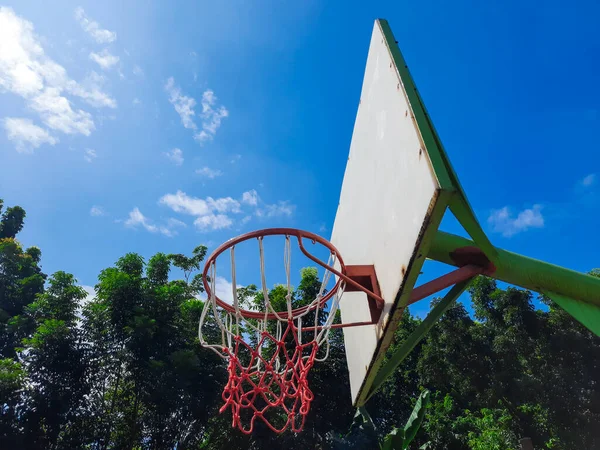 Basketball hoop with net under a blue sky