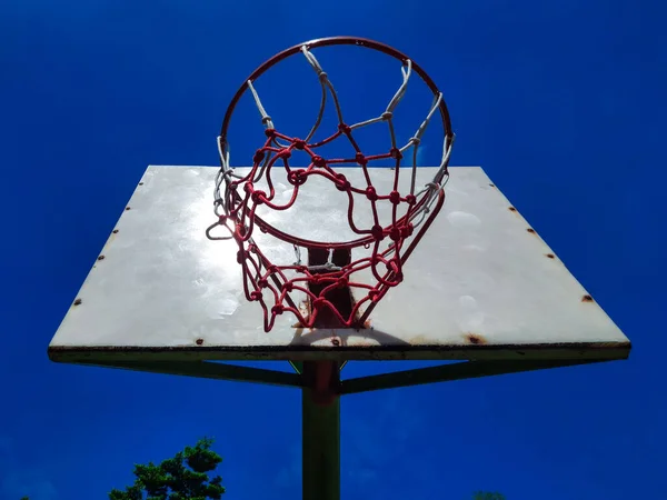Basketball hoop with net under a blue sky