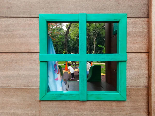 Green square wooden window in wooden house children\'s playground outdoor