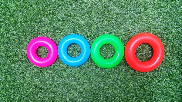 Arrangement of plastic toy rings on artificial green grass