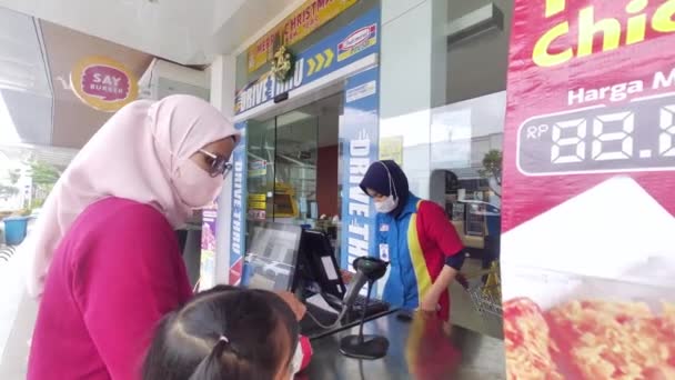 ジャカルタ北部 インドマレットブティックPik のミニマーケットでお客様にサービスを提供するアジアの女性キャッシャー ヒジャーブを着たアジア系女性 インドネシア ジャカルタ 2022年12月24日 — ストック動画