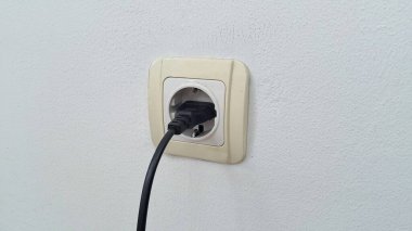 Elektrik prizi kablosu beyaz duvarda. Elektrik prizi beyaz arkaplanda kabloyla izole edildi.