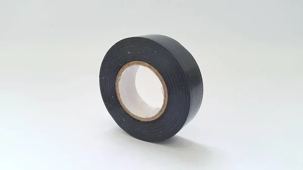 Close up of roll of black sticky duct tape on white background. Black insulating tape or electrical tape.