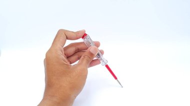 Hand holding voltage measuring pen on white background