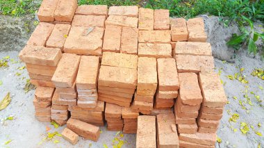 İnşaat için bir yığın yapı malzemesi, yeni kırmızı tuğlalar tam olarak bir araya getiriliyor.