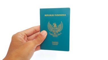 Hand holding Indonesia passport isolated on white background. Travel concept.