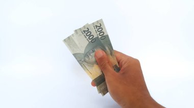Hand holding Indonesian Rupiah money on white background. Two thousand Indonesian Rupiah banknotes.
