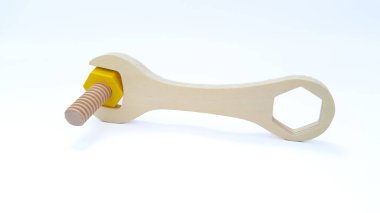 Close up of wooden spanner with wooden bolt isolated on white background