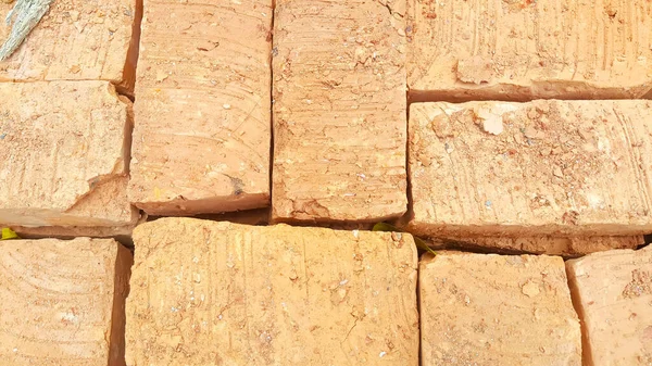 A pile of building materials, stack of new red bricks for construction are accurately put together