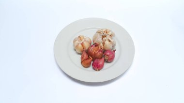 Raw whole garlic and shallot on white plate isolated on white background