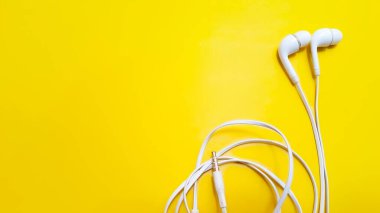 White earphones isolated on yellow background