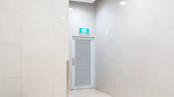 A white emergency exit door in the shopping mall building