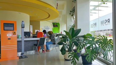 Depok, Endonezya - 18 Mart 2023: UI hastanesindeki yönetim binasının iç görünümü. Resepsiyonist hastaya hizmet eder. Endonezya Üniversitesi Hastanesi (RSUI).