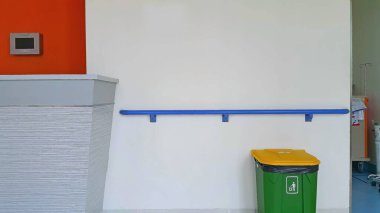 Yerde ve duvarda yaşlı ya da engelli insanlar için tırabzan bulunan kapalı çöp kutusu var. Huzurevi tırabzanı.