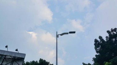 Mavi gökyüzünde bir sokak lambası ve arka planda bulutlar