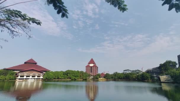 インドネシアのデポック 2023年6月29日 インドネシアのデポックにあるインドネシア大学の建物を背景にしたケナンガ湖の眺め 澄んだ青空 — ストック動画