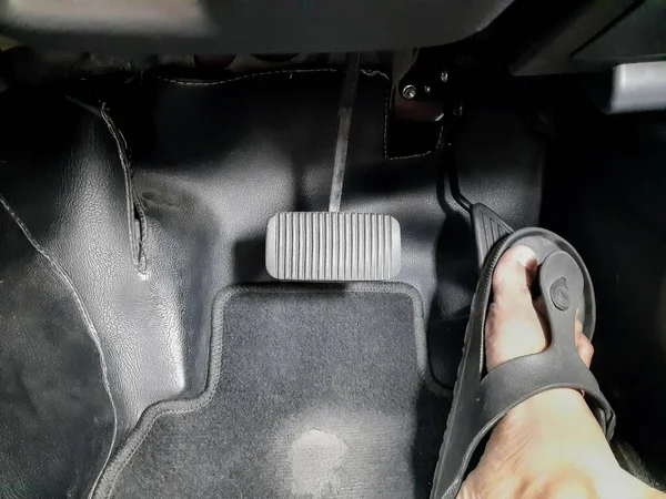 Close up images of man driving car by pushing accelerator and brake pedal with right foot with slippers
