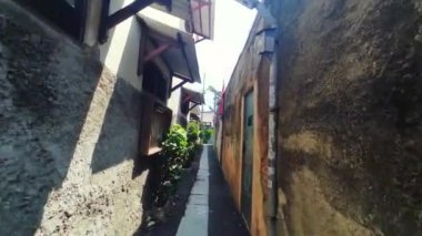 Jakarta 'da kalabalık bir yerleşim bölgesinde dar bir sokakta yürüyorum. Banliyö bölgesi.