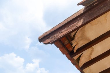 Çürümüş çatının temiz mavi gökyüzü manzarası. Hasarlı çatı.