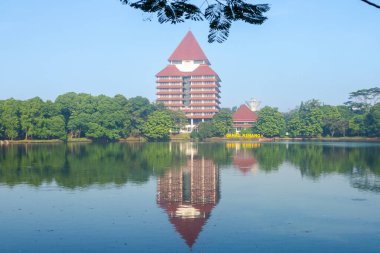 Depok, Indonesia - April 10, 2024: View of the rectorate building of University of Indonesia and Kenanga lake at Depok, Indonesia. clipart