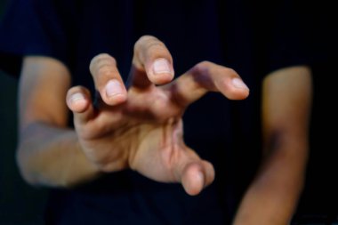 Siyah arka planda bir şey yakalamak için sürükleyici duruşu olan bir adam. Bir şey almaya çalışıyorum..