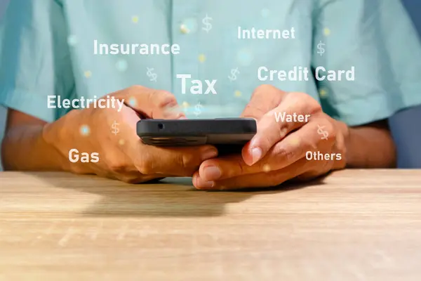 stock image Man using a smartphone to calculate the monthly bills or household expenses