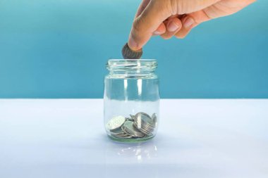 Tasarruf konsepti olarak cam kavanoza bozuk para koymak.