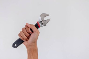 Beyaz arkaplanda ayarlanabilir anahtar ya da ayarlanabilir anahtarı tutan kişi