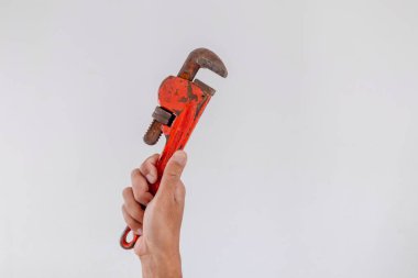 Beyaz arka planda boru anahtarı tutan bir el.