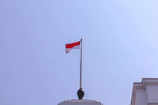 stock image An Indonesian red and white flag flies above a colonial architectural building