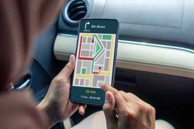 Arabada elinde GPS haritalı bir cep telefonu olan bir kadın.