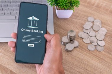 Çevrimiçi mobil bankacılığa erişmek için akıllı telefon tutan bir erkek. Mobil bankacılığa erişmek için kullanıcı adı ve parola girin.