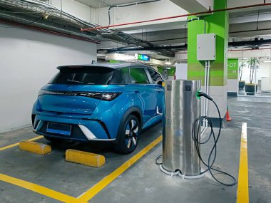 Jakarta, Endonezya - 30 Ekim 2024: Bodrum katındaki bir otoparkta şarj olan elektrikli bir arabanın görüntüsü