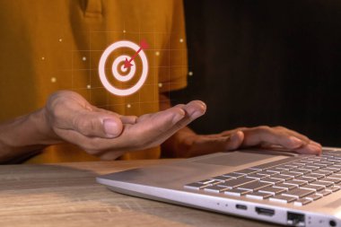 Adam iş hedefi için sanal bir hedef simgesi tutuyor. Hedefler, strateji, planlama ve başarı kavramı