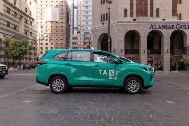 Madinah, Suudi Arabistan - 18 Aralık 2024: Medine şehrinde yeşil bir taksi