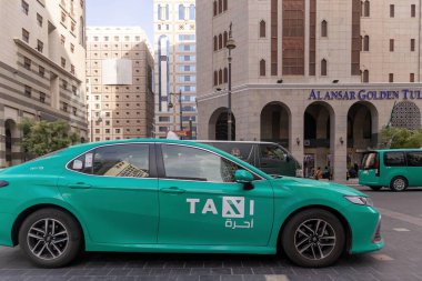 Madinah, Suudi Arabistan - 18 Aralık 2024: Medine şehrinde yeşil bir taksi