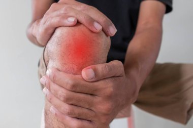 Acı veren dizini tutan bir adamın yakın görüntüsü