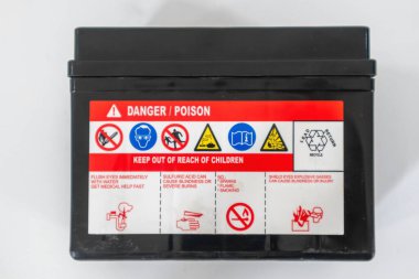 A danger sign and symbol sticker on a motorbike battery clipart