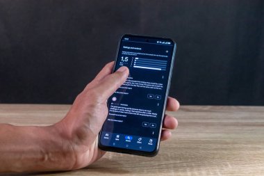 Jakarta, Endonezya - 08 Şubat 2025: Play Store 'daki başvuru notunu kontrol etmek ve gözden geçirmek için akıllı telefon tutmak. En kötü reyting.