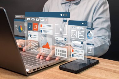 Cep telefonu ve laptop uygulama arayüzü tasarımını geliştirmek için dizüstü bilgisayar üzerinde çalışan bir web geliştiricisi. UX-UI geliştirme kavramı.