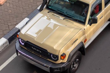 Jakarta, Endonezya - 04 Mayıs 2025: Toyota Land Cruiser 70 serisi yol kenarında kumlu taupe rengi